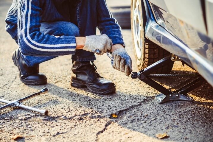 A mechanic jacking up a car